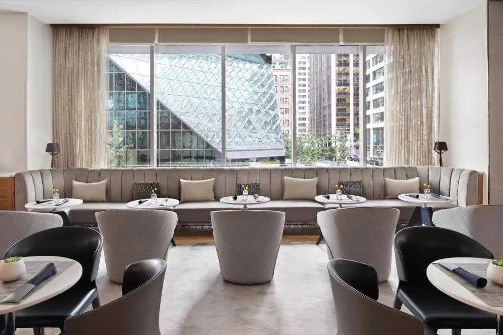 a restaurant with tables and chairs and a large window at AC Hotel by Marriott New York Downtown in New York