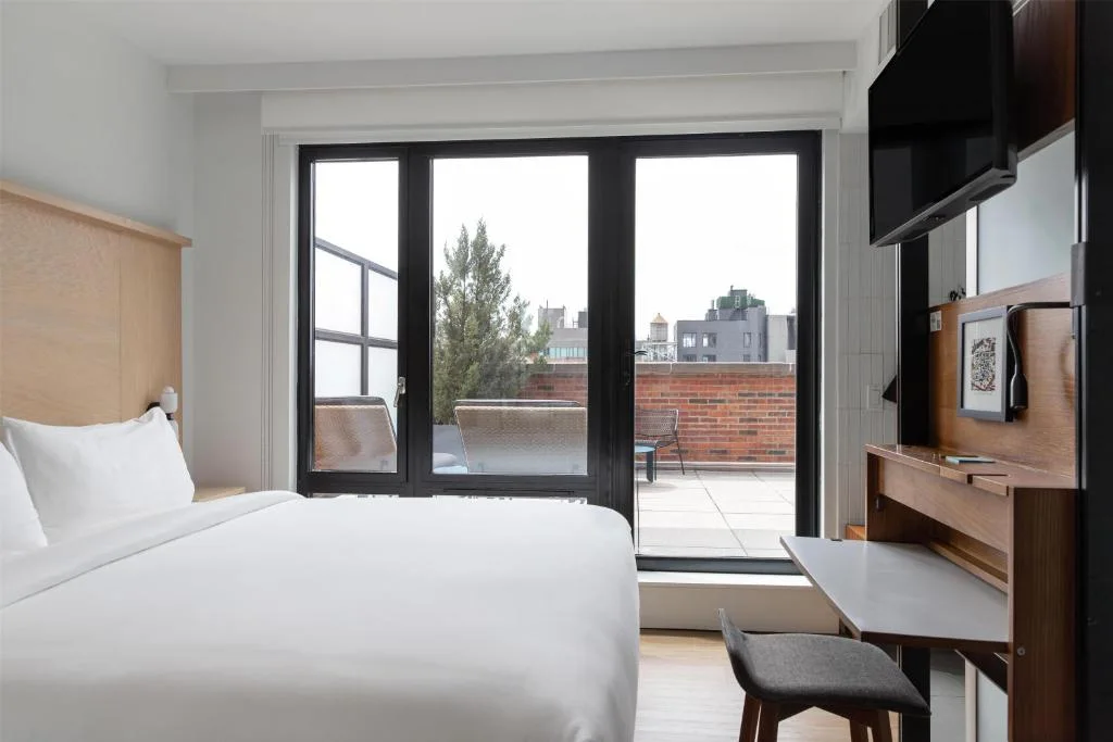 a bedroom with a bed and a large window at Arlo SoHo in New York