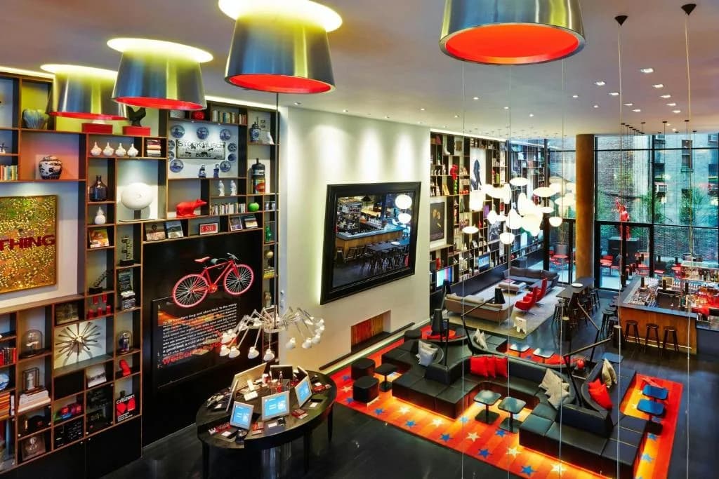 a room filled with lots of furniture and lights at citizenM New York Times Square in New York