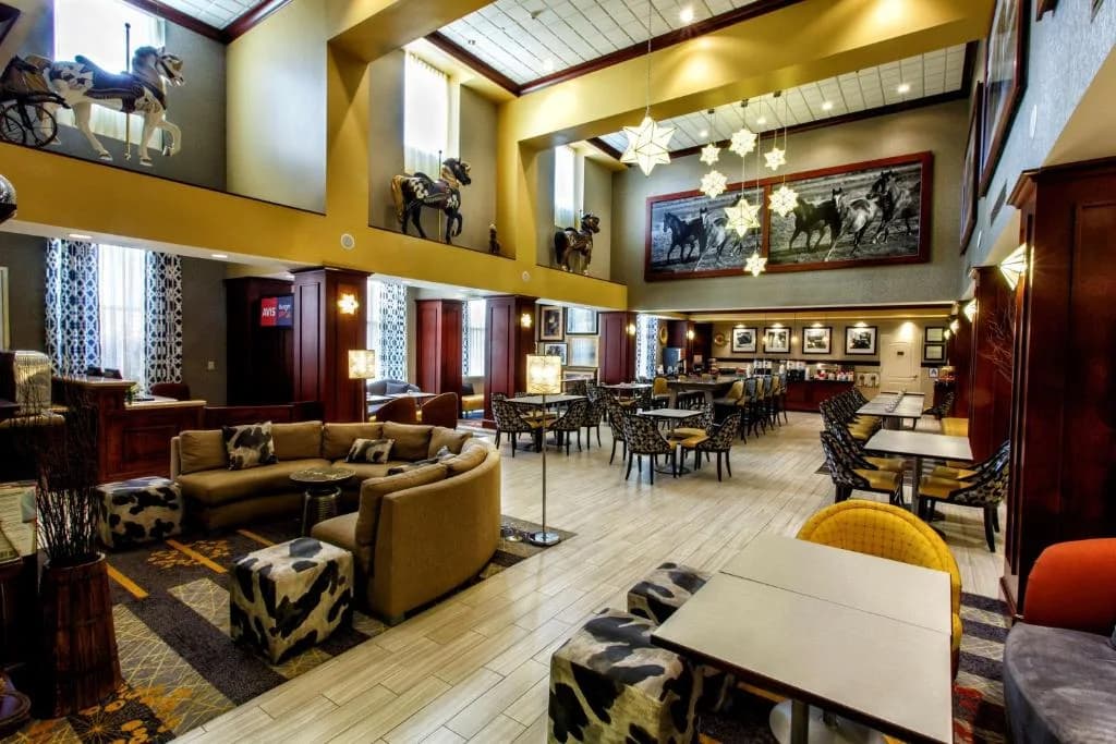 a lobby of a hotel with couches and tables at Hampton Inn & Suites Staten Island in Staten Island