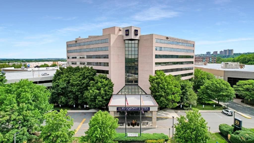 a large building with a clock tower in front of it at Harmony Suites Secaucus Meadowlands in Secaucus