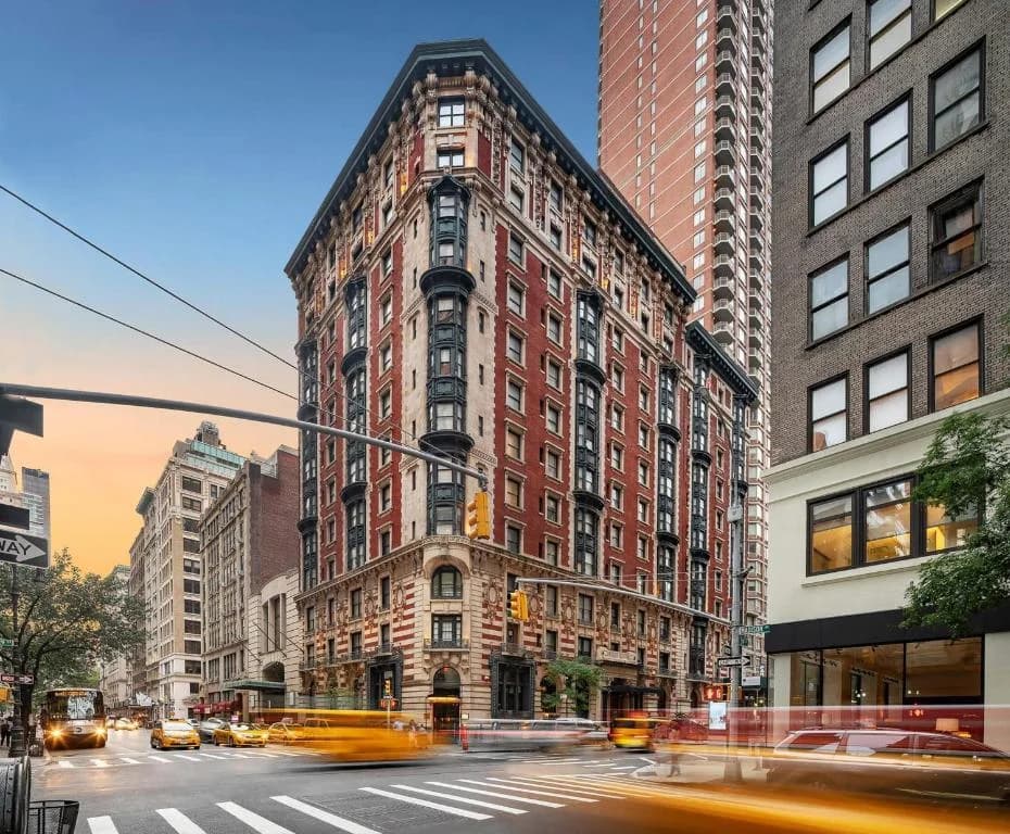 a tall building on a busy city street with taxis at Hotel Seville NoMad - The Unbound Collection by Hyatt in New York