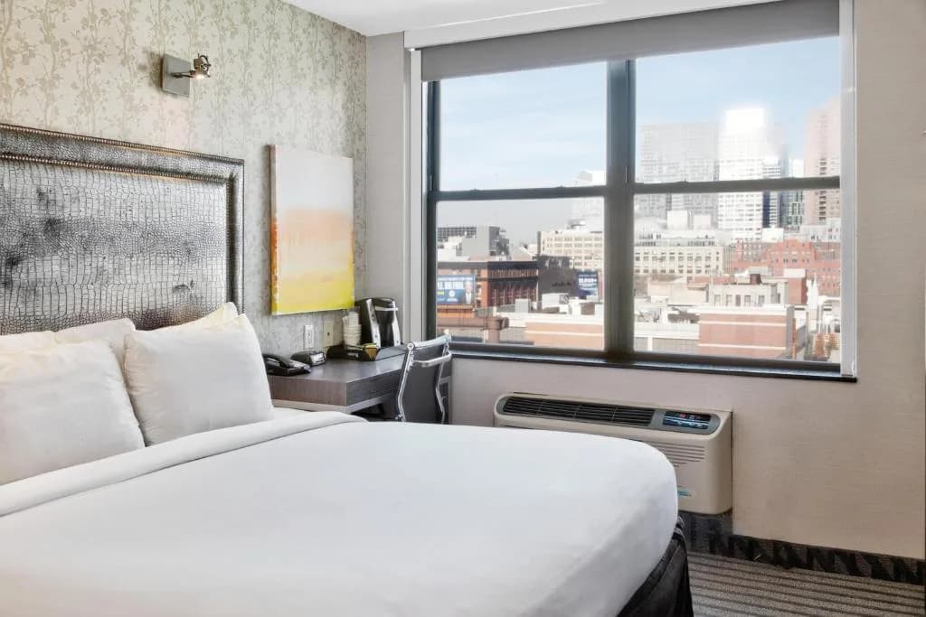 a bedroom with a bed and a large window at Times Square West Hotel, BW Signature Collection in New York