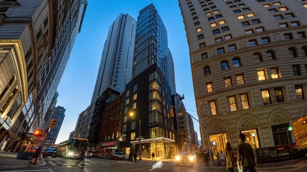 a busy city street with tall buildings and people walking at Hotel Indigo NYC Financial District by IHG in New York