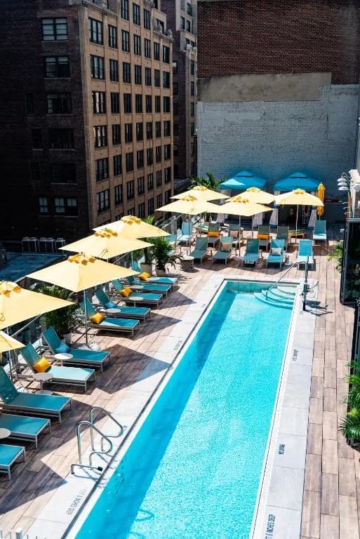 an outdoor swimming pool with umbrellas and chairs at Margaritaville Resort Times Square in New York