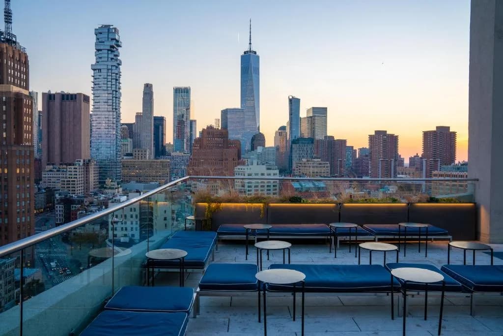 a rooftop patio with tables and chairs and a city skyline at ModernHaus SoHo in New York