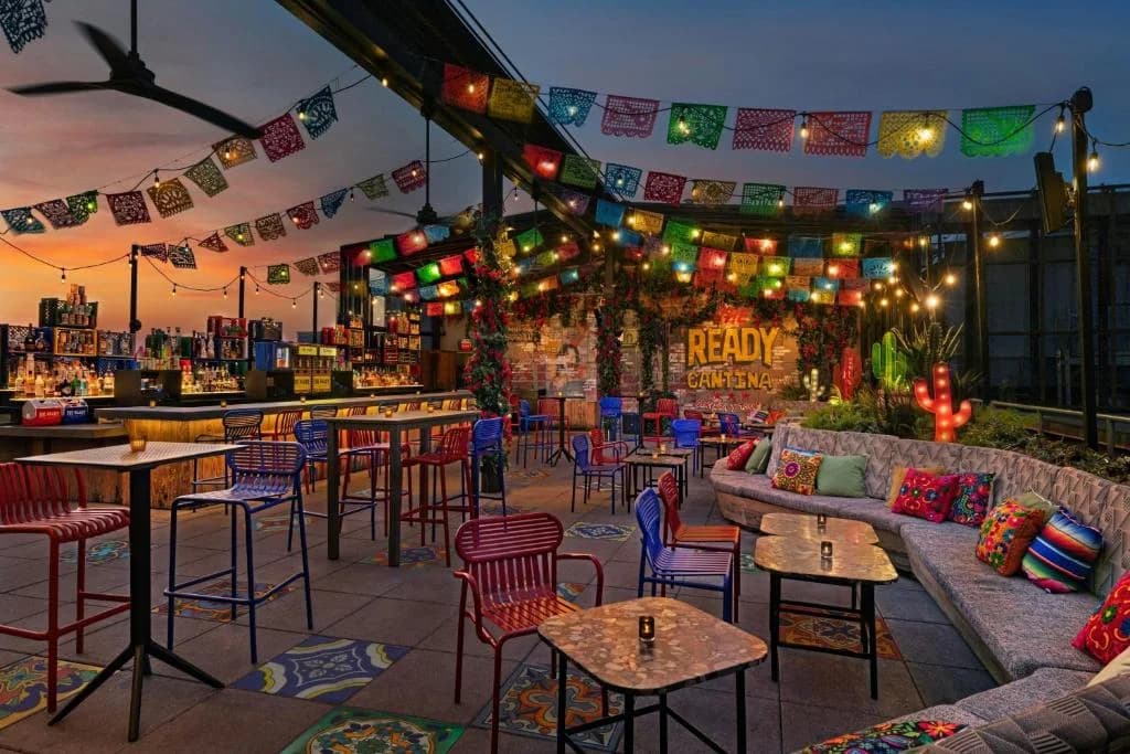 a restaurant with tables and chairs and a bar at Moxy NYC East Village in New York