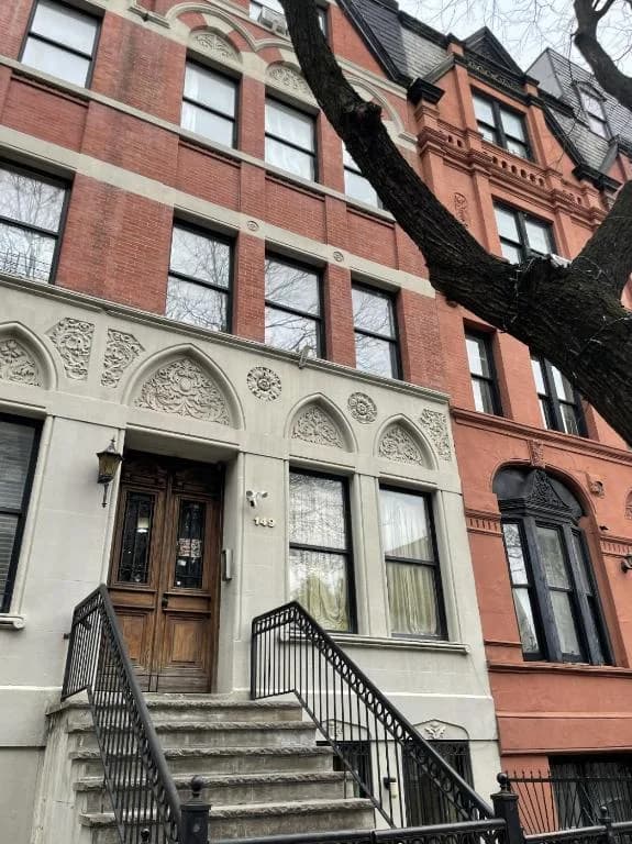a brick building with stairs leading to a door at NYC Townhouse Apartment in New York