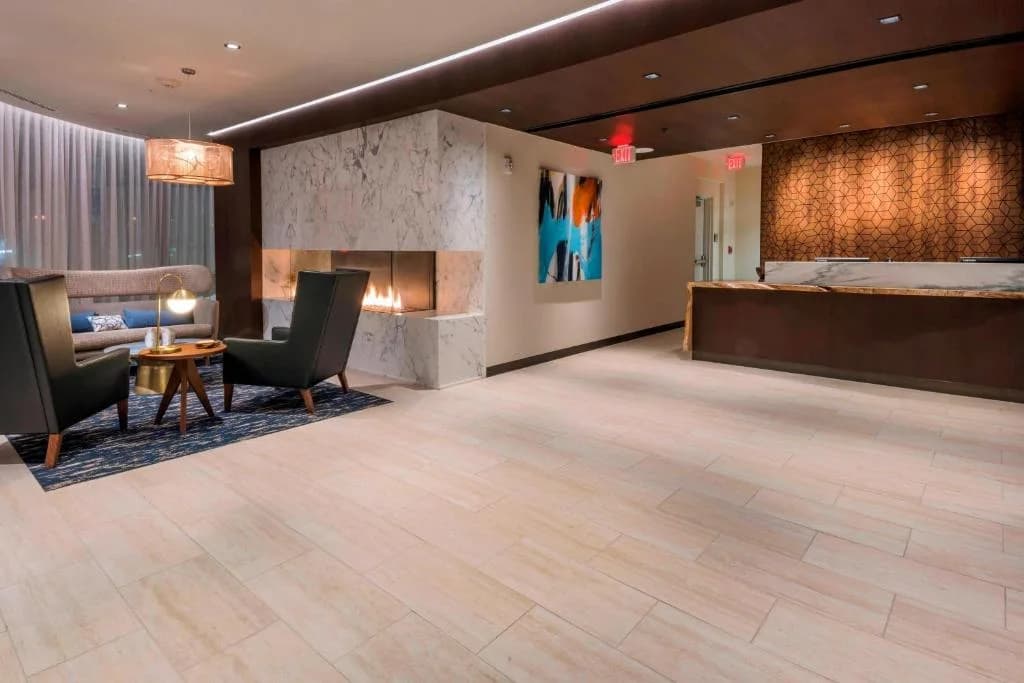 a hotel lobby with a bed and a desk and chairs at Residence Inn by Marriott Jersey City in Jersey City