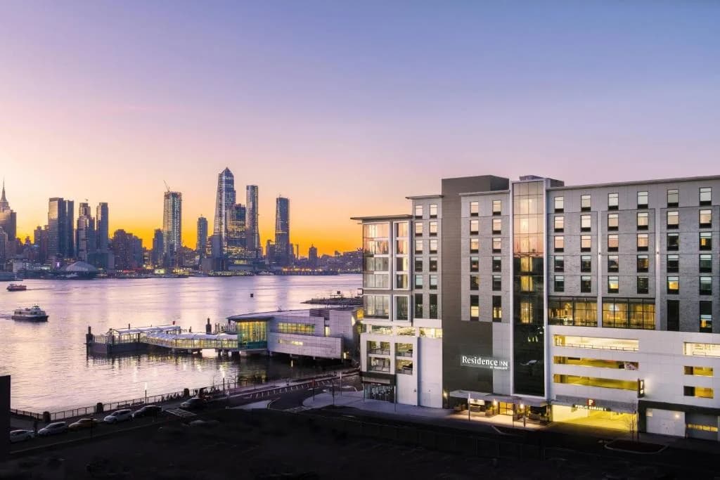 a large building next to a body of water at Residence Inn by Marriott Weehawken in Weehawken