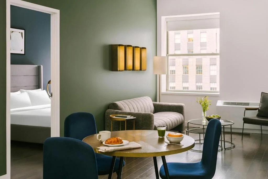 a hotel room with a table and chairs and a bed at Nester Finn Financial District in New York