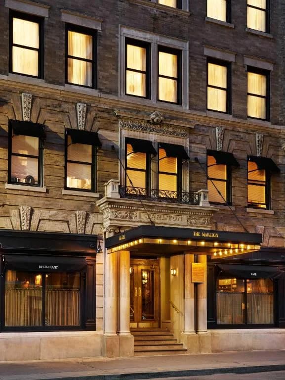 a large brick building with lights in the windows at The Marlton Hotel in New York