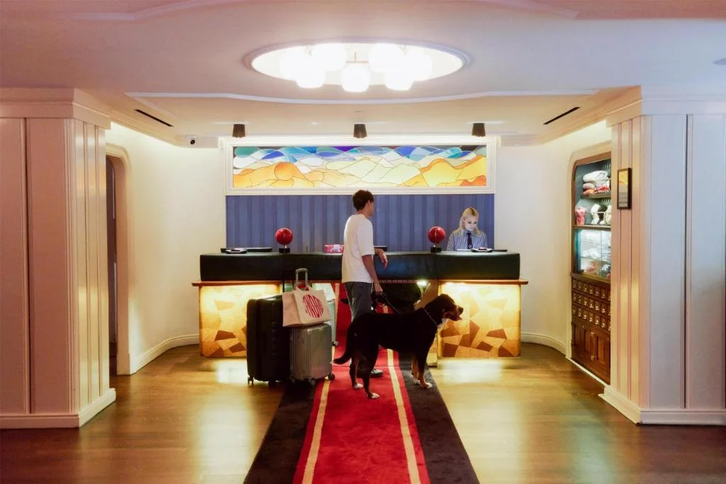 a man and a dog standing in a hotel lobby at The Standard - East Village in New York