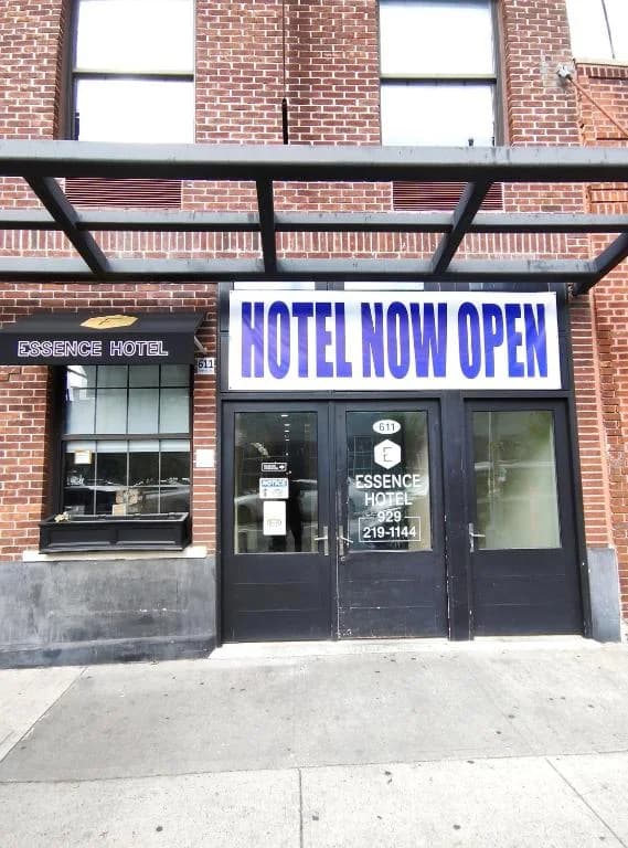 a hotel now open sign in front of a building at Essence hotel in Brooklyn