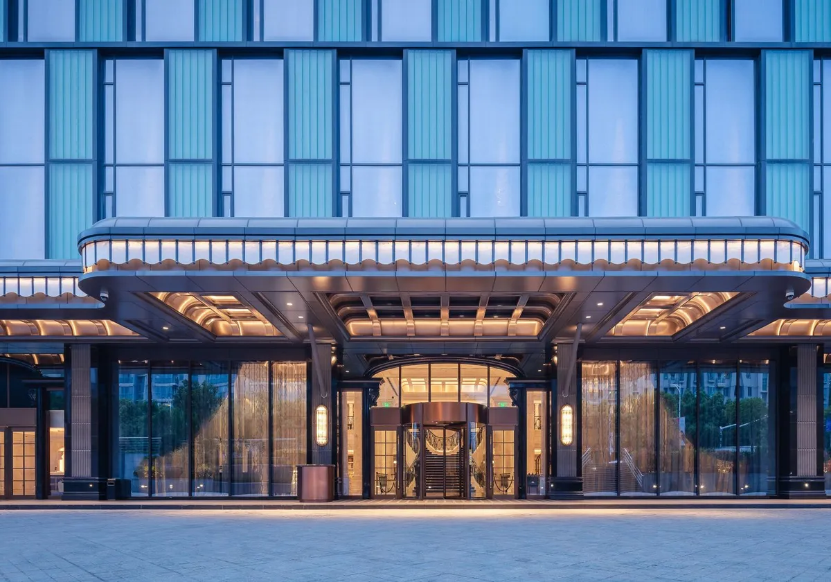 Elegant modern hotel entrance with glass facade and ambient lighting.