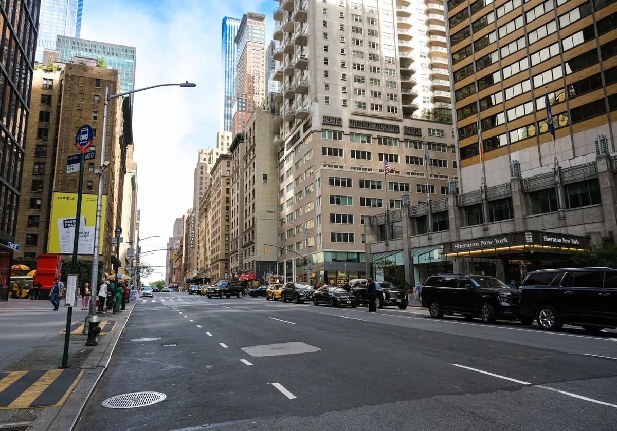 Urban cityscape of Midtown Manhattan with skyscrapers, vehicles, and pedestrians.
