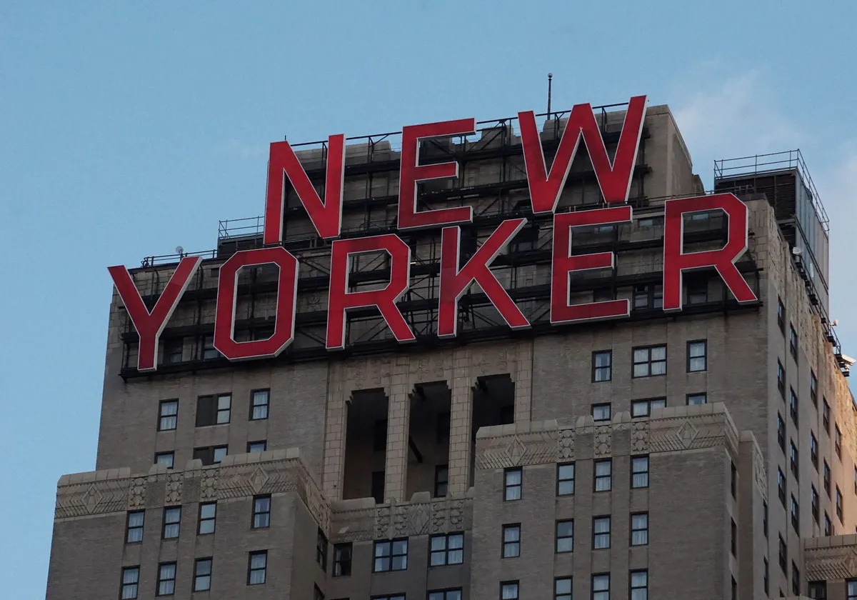 Close-up view of the iconic New Yorker Hotel sign against a clear blue sky in NYC.