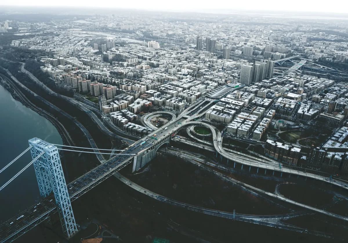 Drone view of George Washington Bridge crossing river and connecting districts of New York City against cloudy sky