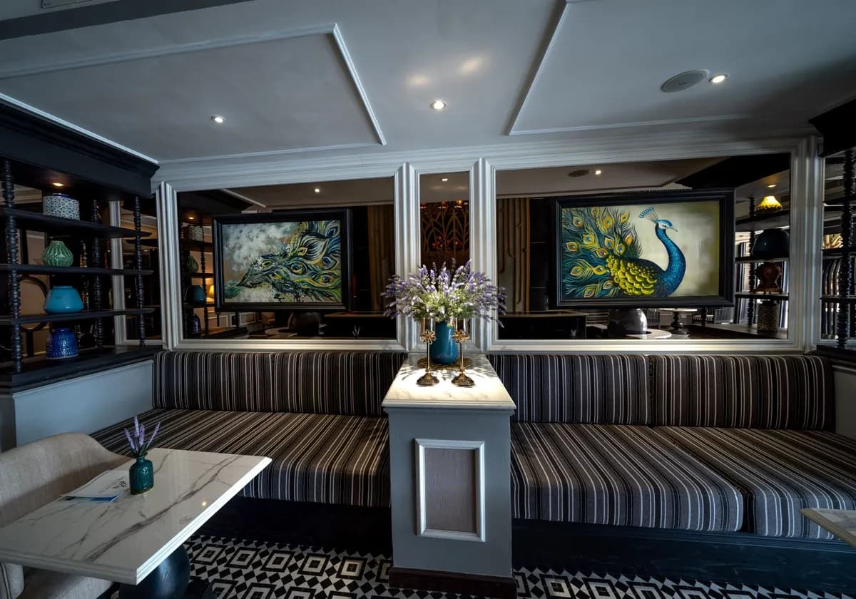 Luxurious hotel foyer adorned with peacock paintings and elegant seating. Perfect for relaxation.