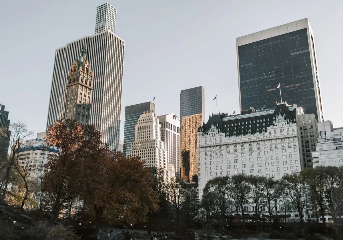 View of New York City's skyscrapers from Central Park with autumn foliage.