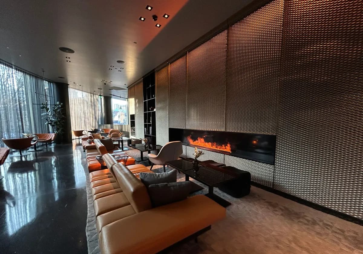 Luxurious modern hotel lounge featuring a sleek design and warm fireplace.