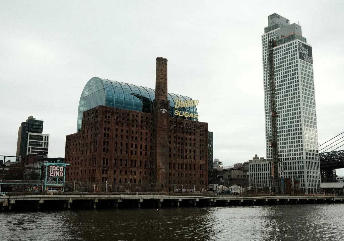 Historical Domino Sugar Refinery by the riverfront in Brooklyn with modern skyscrapers, NYC.
