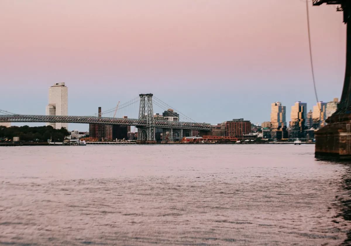 Williamsburg Bridge across East River placed in New York City at sunset