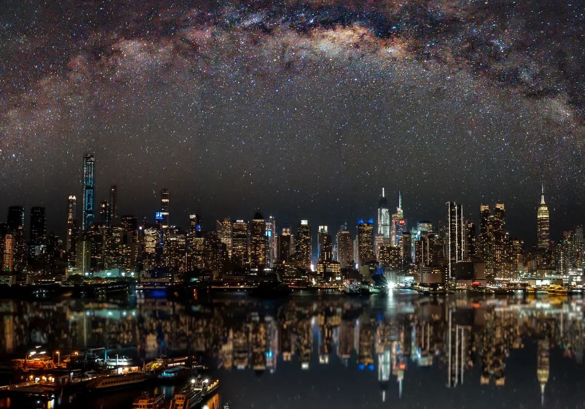Nighttime view of New York City with stars reflecting on the water.