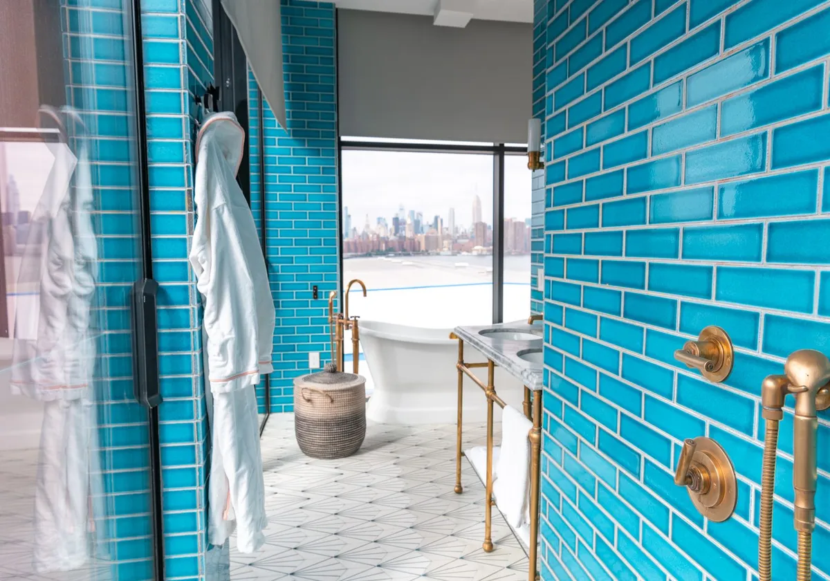 Elegant modern bathroom with vibrant blue tiles and skyline view, embodying luxury and style.