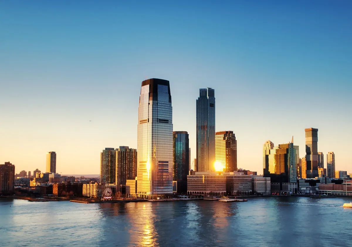 Breathtaking sunrise view over New York City skyline with reflection on the water.