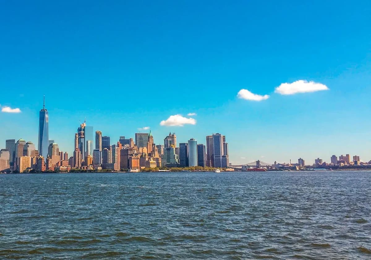 Stunning view of New York City skyline with blue skies from the waterfront.