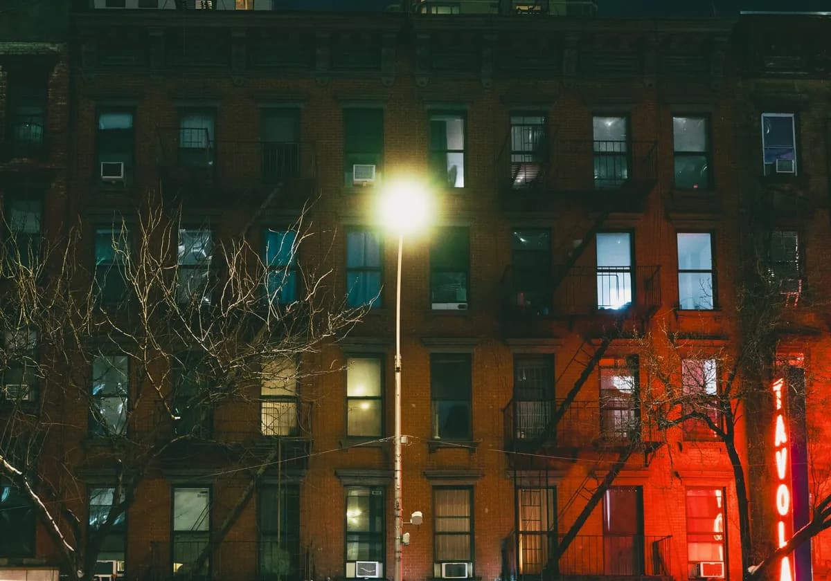 Capture of a dimly lit New York City building facade at night, highlighting urban architecture.