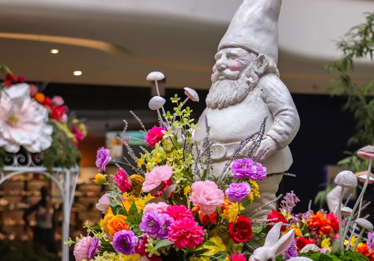 A playful indoor garden scene with a gnome surrounded by vibrant flowers and mushrooms.