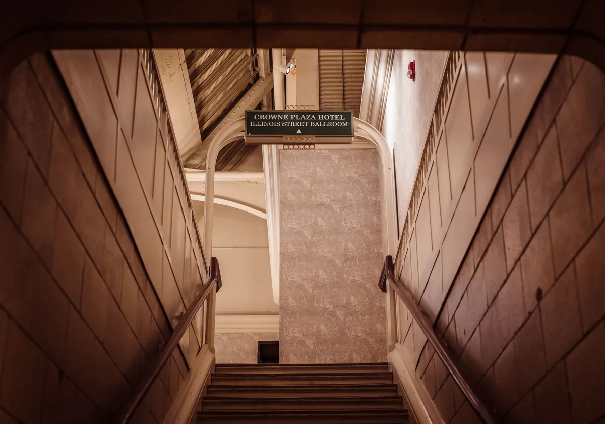 Aesthetic view of stairs leading to Crowne Plaza Hotel Ballroom with classic interior design.