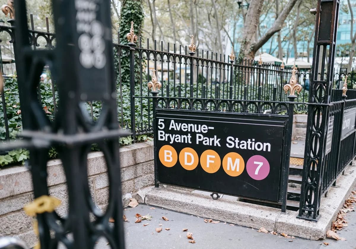 Signboard with information of route hanging on fence at entrance of subway station in New York