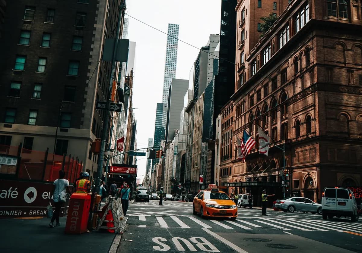 Vibrant New York City street with yellow taxi, skyscrapers, and city life captured in Midtown Manhattan.