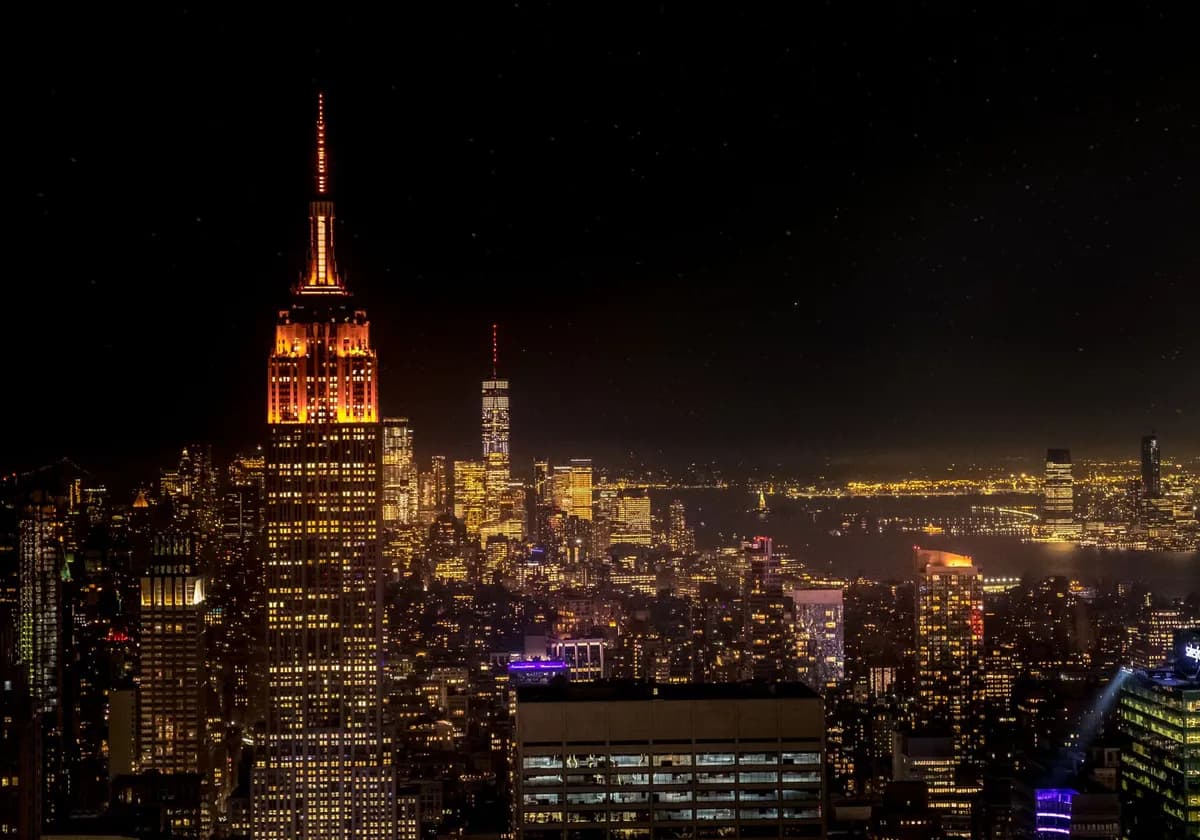 A beautiful nighttime view of New York City's iconic skyline featuring the Empire State Building.