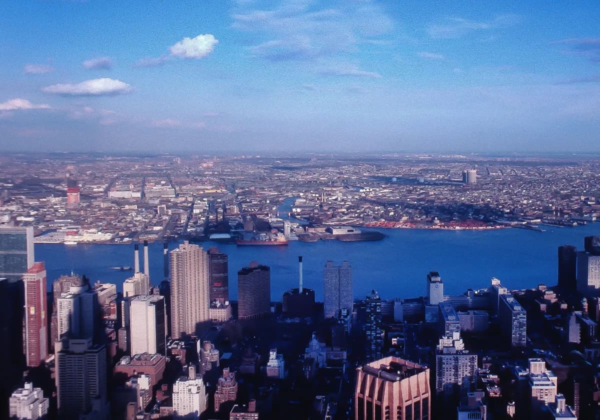 Stunning aerial view of New York City skyline with Hudson River and clear skies.