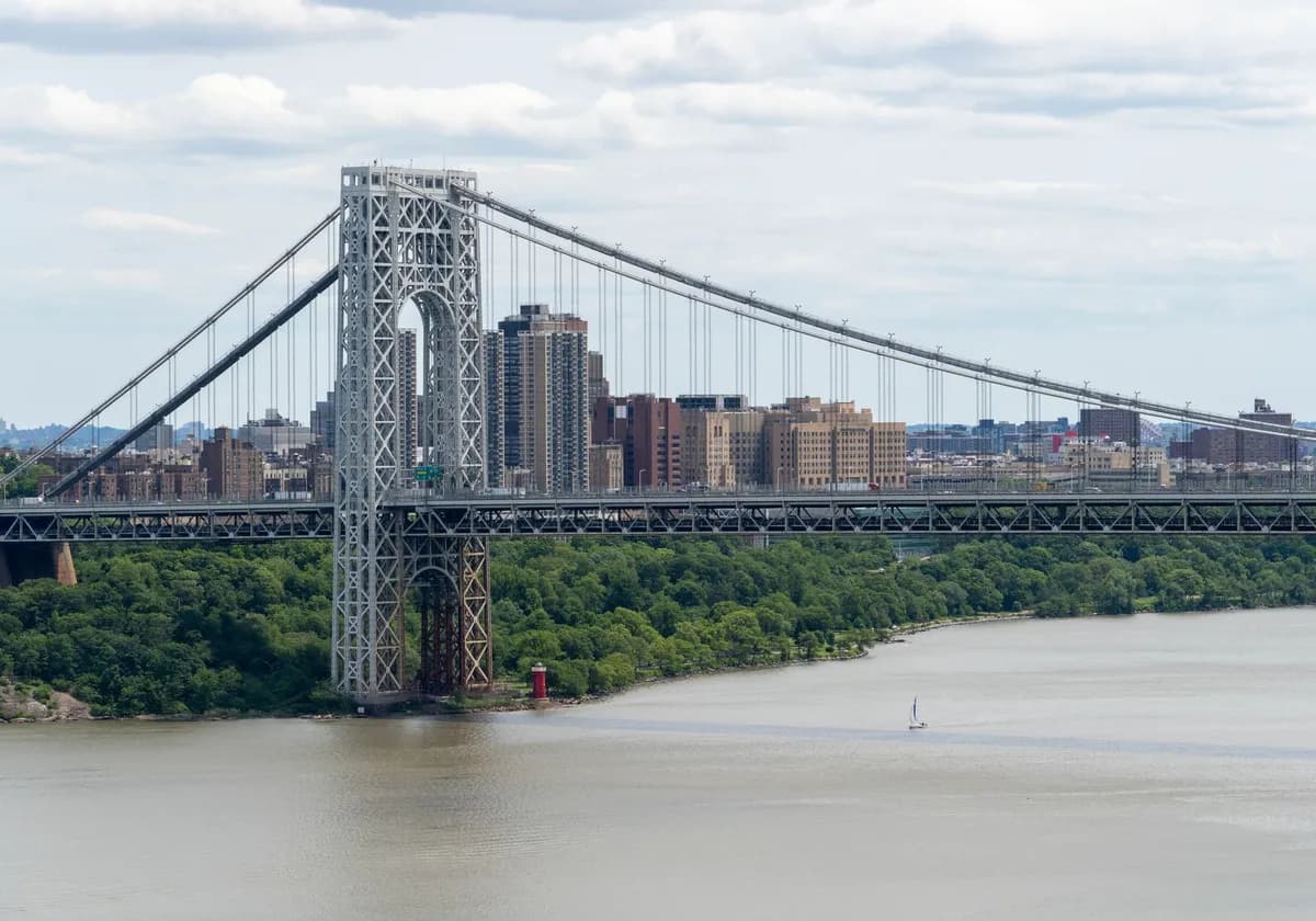 Stunning view of George Washington Bridge spanning the Hudson River with Manhattan cityscape backdrop.