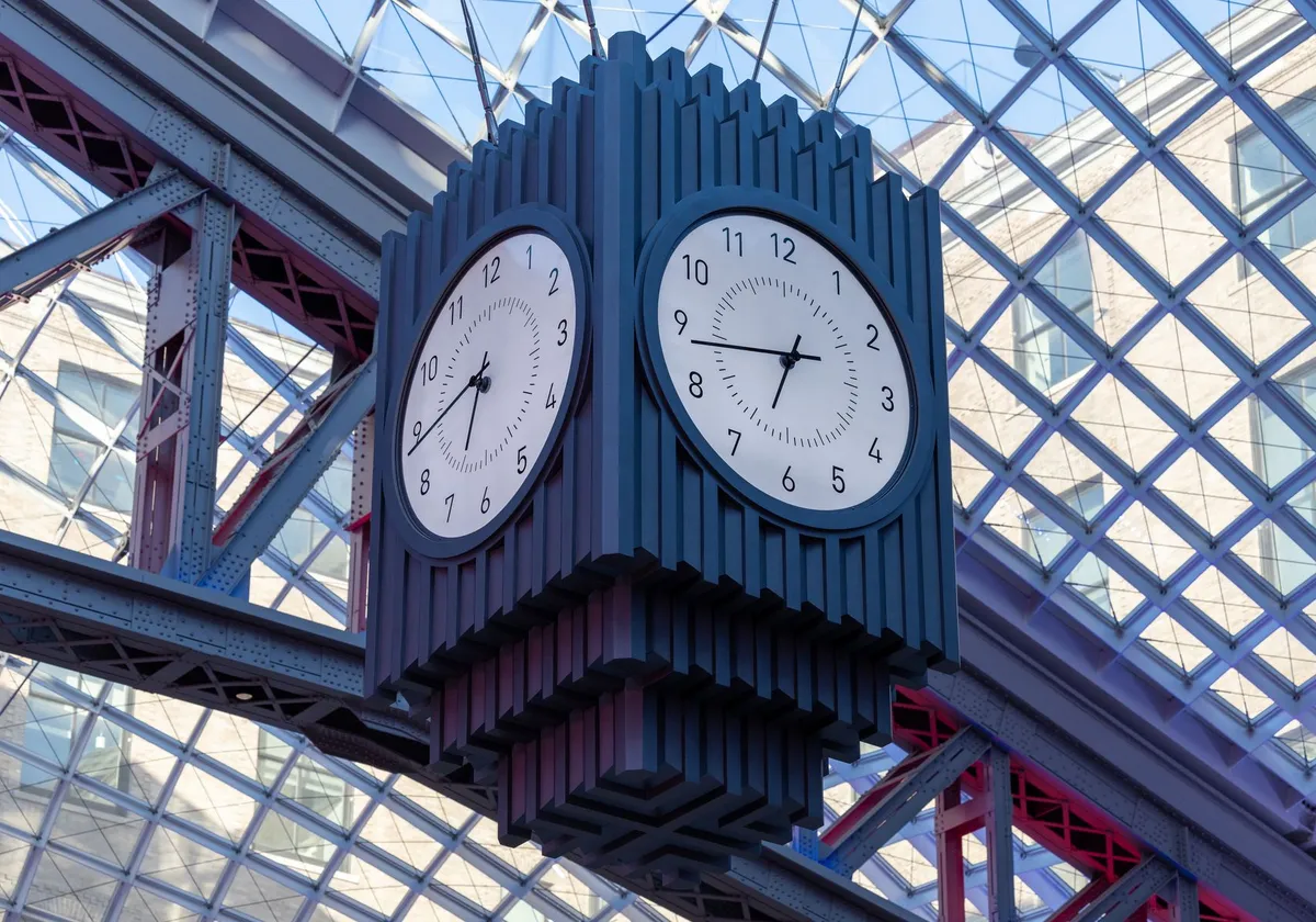 Close-up of an architectural clock at Penn Station, New York, showcasing modern design and urban landscape.