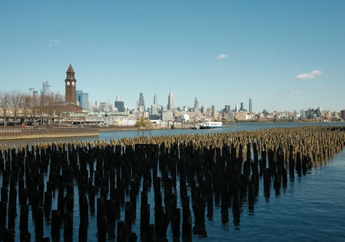 Scenic view of New York City skyline from Hoboken waterfront with wooden piers in the foreground.