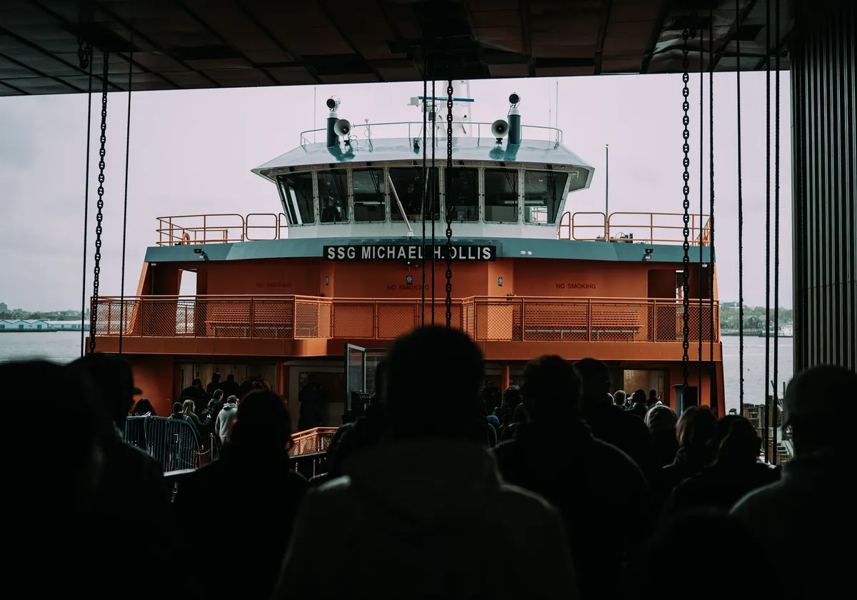 People boarding the Staten Island Ferry in New York City on a cloudy day.