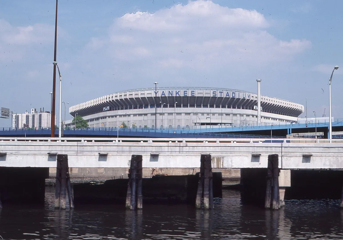 A scenic view of Yankee Stadium visible from a nearby waterfront bridge in New York.
