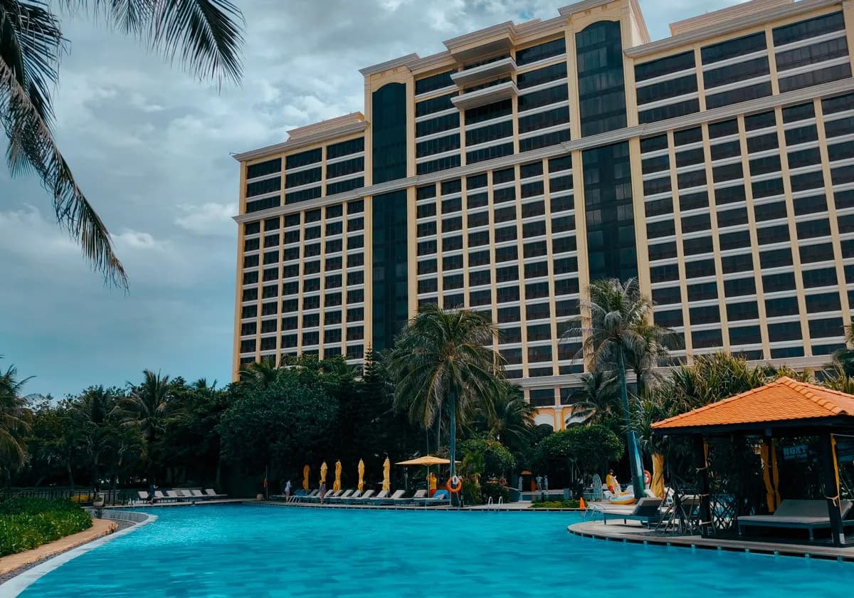 Stunning resort building with a tropical poolside setting and palm trees in a vibrant outdoor environment.