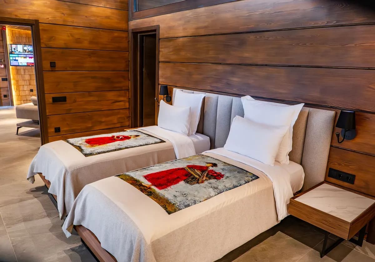 Cozy twin bedroom with wooden paneling and modern decor in a luxury Tbilisi hotel.