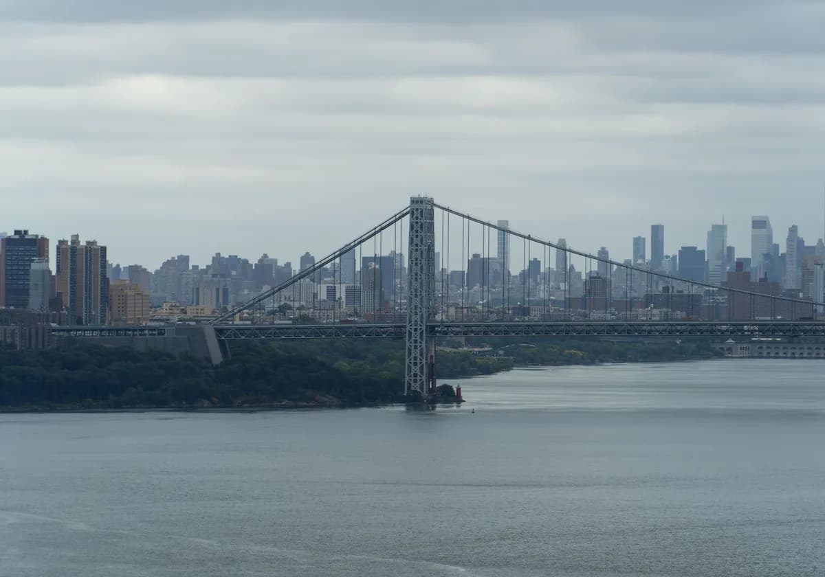 View of the George Washington Bridge and New York City skyline over the Hudson River.
