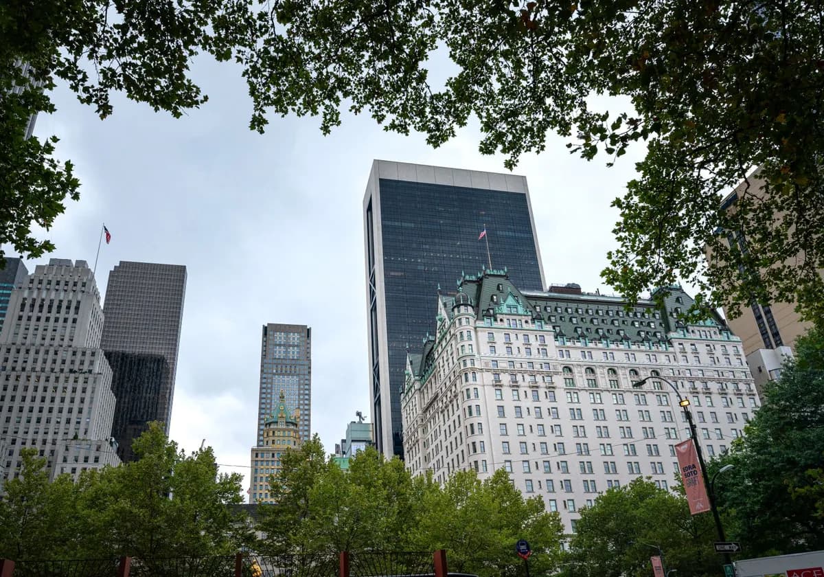 View of iconic buildings in New York City skyline surrounded by foliage.