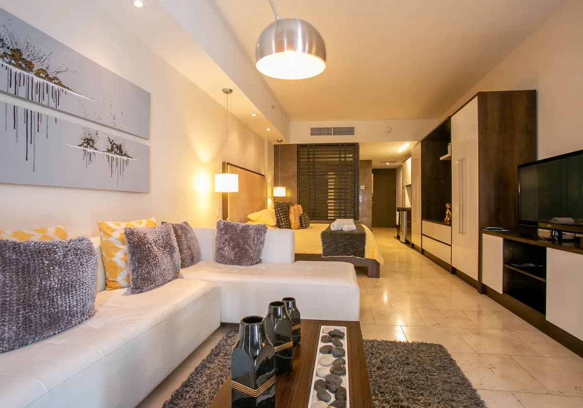 Spacious hotel room with contemporary decor and cozy furnishings.